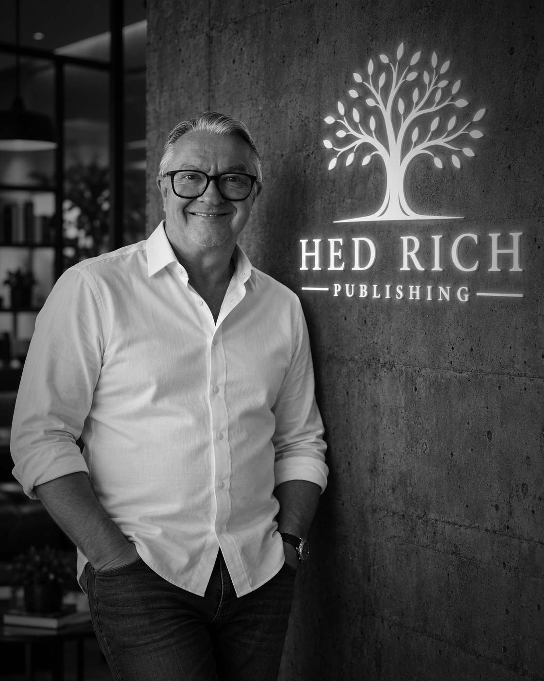 Mik Hedrich vor dem beleuchteten Logo von Hed Rich Publishing